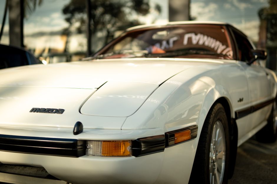 A vintage white Mazda RX-7 car photographed at a car meet in Brisbane, Australia.