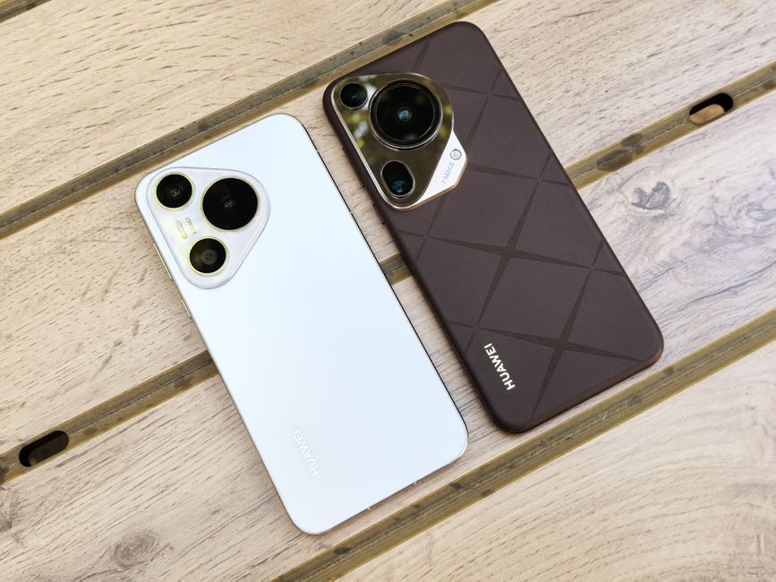 Two Huawei smartphones with sleek designs placed on a wooden table enhance the modern tech aesthetic.