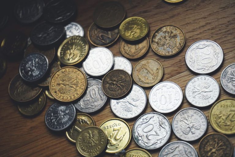 Close-up view of various Polish coins on a wooden table showcasing currency and finance concepts.