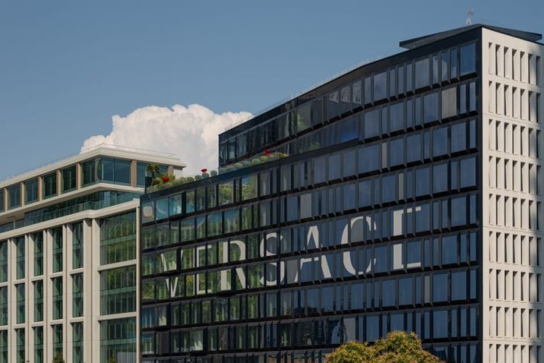 A view of the modern Versace headquarters in Milan, Italy, against a clear blue sky, showcasing its sleek architectural design.