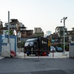Street scene featuring a black delivery truck and surrounding urban landscape at day.