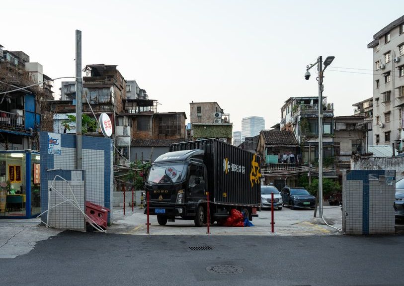 Street scene featuring a black delivery truck and surrounding urban landscape at day.
