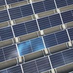 Aerial view of a large array of solar panels on a rooftop, utilizing renewable energy.