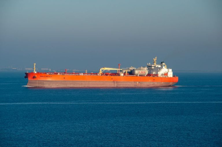 Bright orange LNG carrier ship cruising through calm sea waters on a clear day.