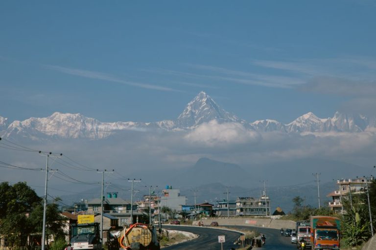 Roadway in Pokhara with stunning Machapuchare mountain in the backdrop under a clear blue sky.