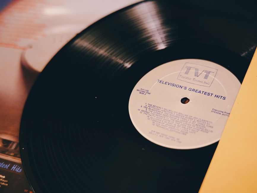 A vintage vinyl record titled 'Television's Greatest Hits' on a turntable.