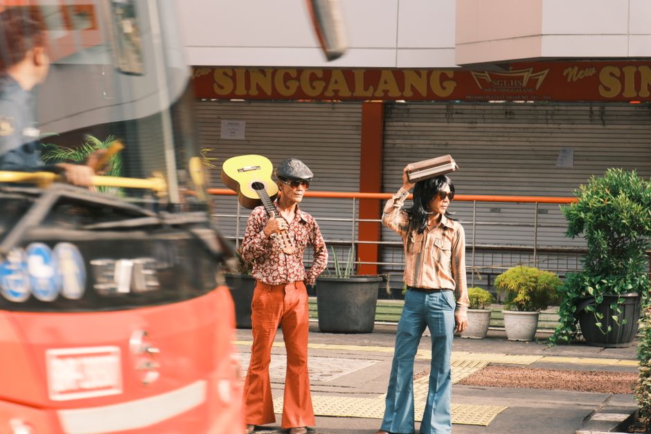 Two stylish street musicians with a guitar and retro outfits in Jakarta, Indonesia