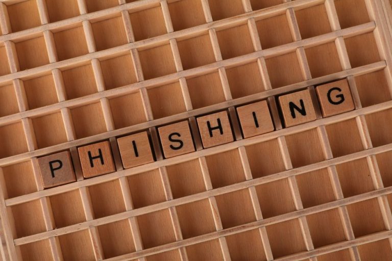 Wooden Scrabble tiles arranged to spell 'Phishing', illustrating online security concepts.