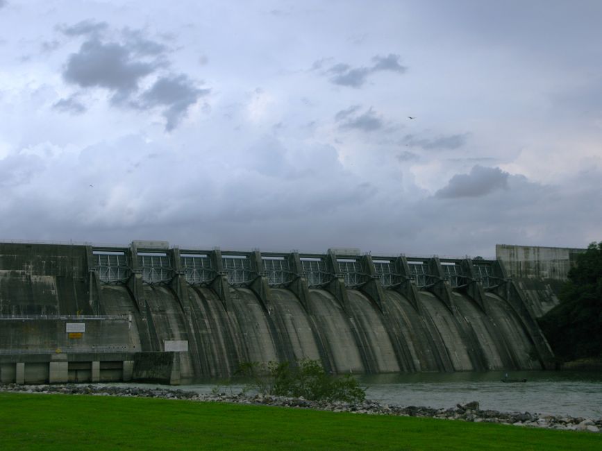 A large concrete dam with stormy sky, showcasing engineering and power generation.