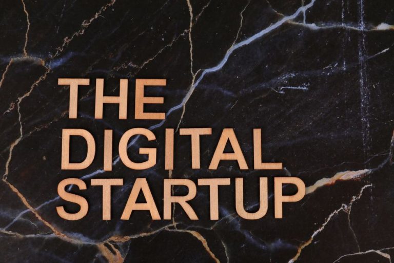 Wooden letters spelling 'The Digital Startup' on a dark marble background. Ideal for business and tech themes.