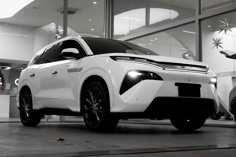 Sleek white electric SUV showcased in a modern indoor showroom. Perfect for automotive enthusiasts.