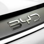 Detailed close-up of the chrome BYD logo on a car, showcasing sleek automotive branding.