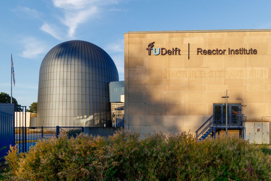 Exterior view of TU Delft Reactor Institute, highlighting dome structure in evening light.