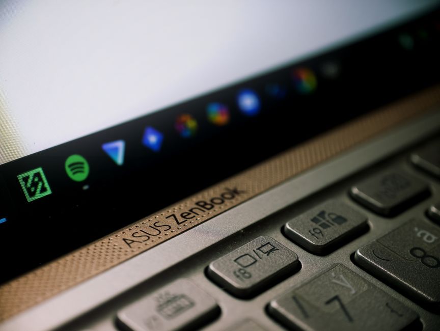 A detailed close-up of an ASUS ZenBook laptop keyboard and screen, showcasing technology in modern workspaces.