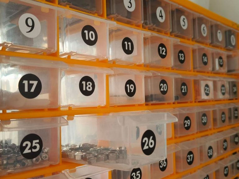 Side view of a hardware storage system with numbered bins containing nuts.