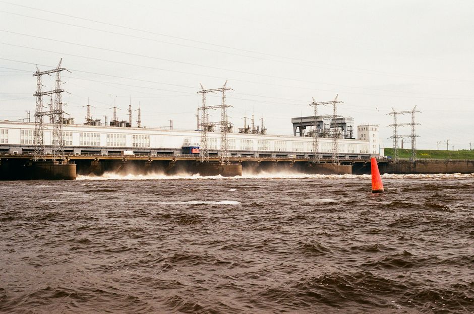 Power plant and river with water flow and industrial infrastructure, showcasing energy production.