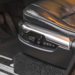 Close-up of a luxury car seat with electric adjustment controls in an SUV interior.