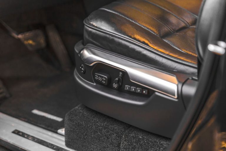 Close-up of a luxury car seat with electric adjustment controls in an SUV interior.