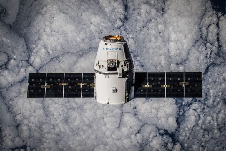 SpaceX Dragon spacecraft in orbit, highlighting advanced space technology with cloud backdrop.