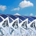 A striking futuristic building design under a bright blue sky in Madrid, Spain.