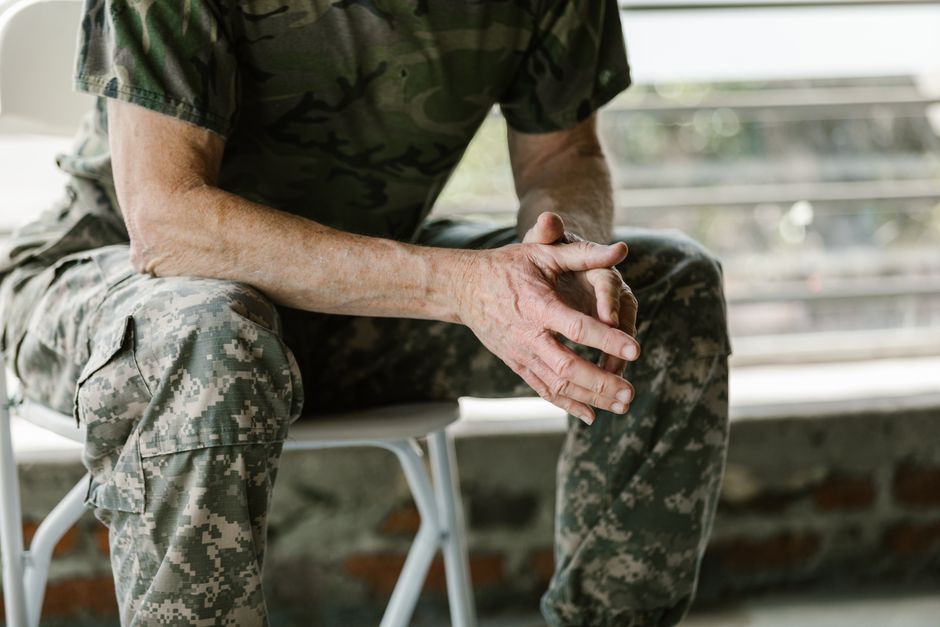 Close-up of a military veteran's hands in a therapy session, emphasizing mental health support.