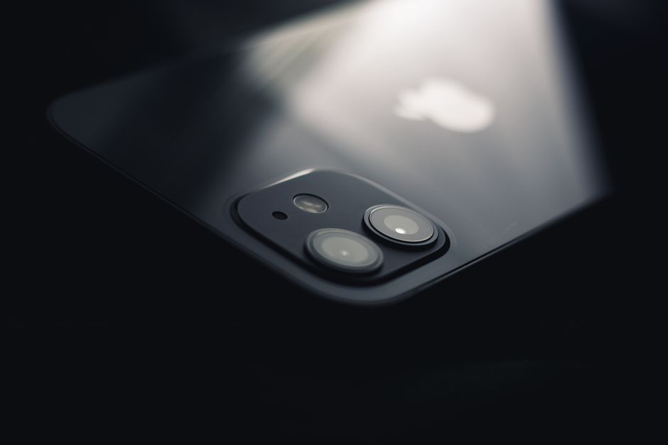 Close-up shot of a smartphone camera lens reflecting light, highlighting modern technology.