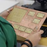 A technician examines a printed circuit board in a modern electronics lab.