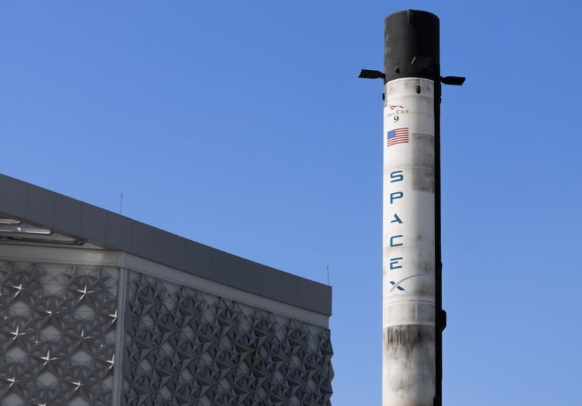 A SpaceX Falcon 9 rocket displayed outdoors against a clear blue sky in Dubai.