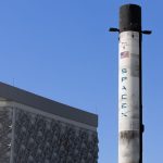 A SpaceX Falcon 9 rocket displayed outdoors against a clear blue sky in Dubai.