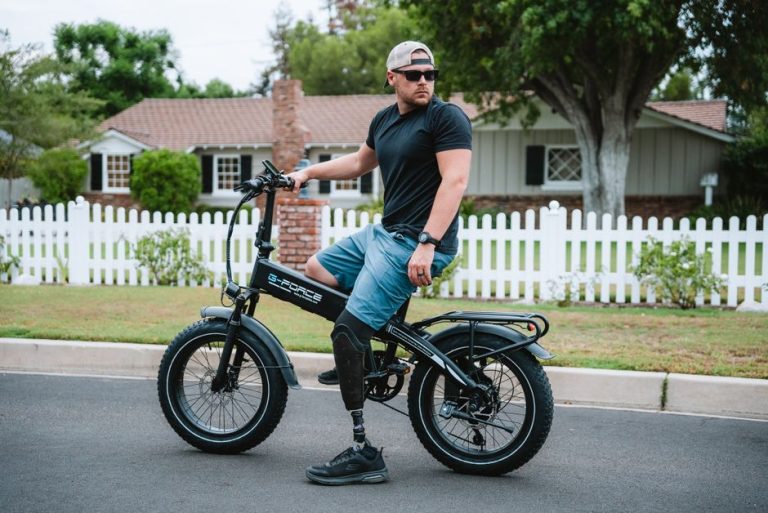 Man with prosthetic leg on bicycle in a residential neighborhood, showcasing strength and determination.