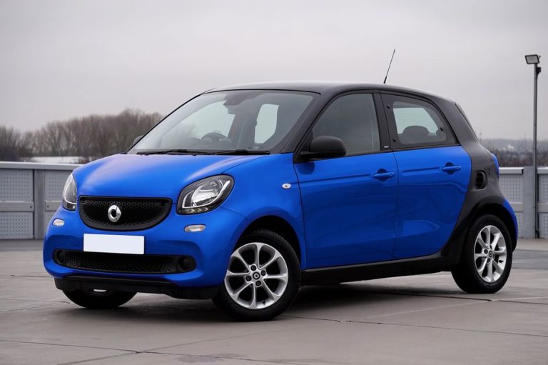 A sleek blue Smart Forfour car parked outdoors in an urban setting.