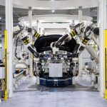 High-tech robots assembling a car in a modern factory setting, showcasing automation.