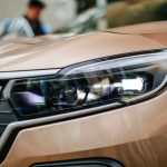 Detailed close-up of a sleek brown electric SUV headlight with stylish design.
