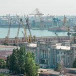 Industrial cranes and buildings at Constanța Port during daytime, Romania's bustling hub.