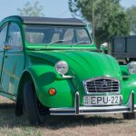A vibrant green vintage car with license plate EPU-221 parked outdoors.