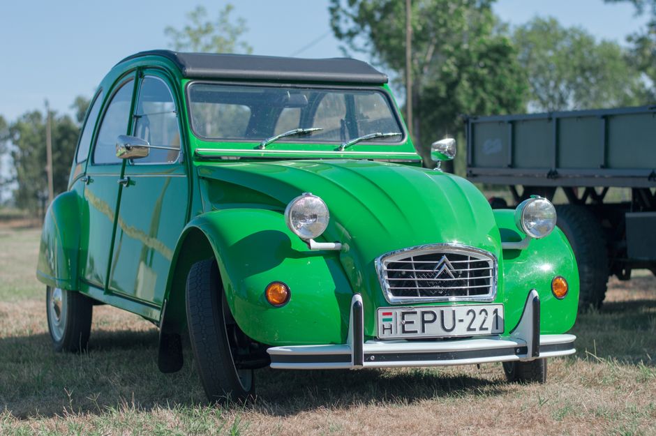 A vibrant green vintage car with license plate EPU-221 parked outdoors.