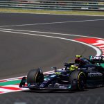 Dynamic shot of a Formula 1 car speeding around a track curve, showcasing motorsport excitement.