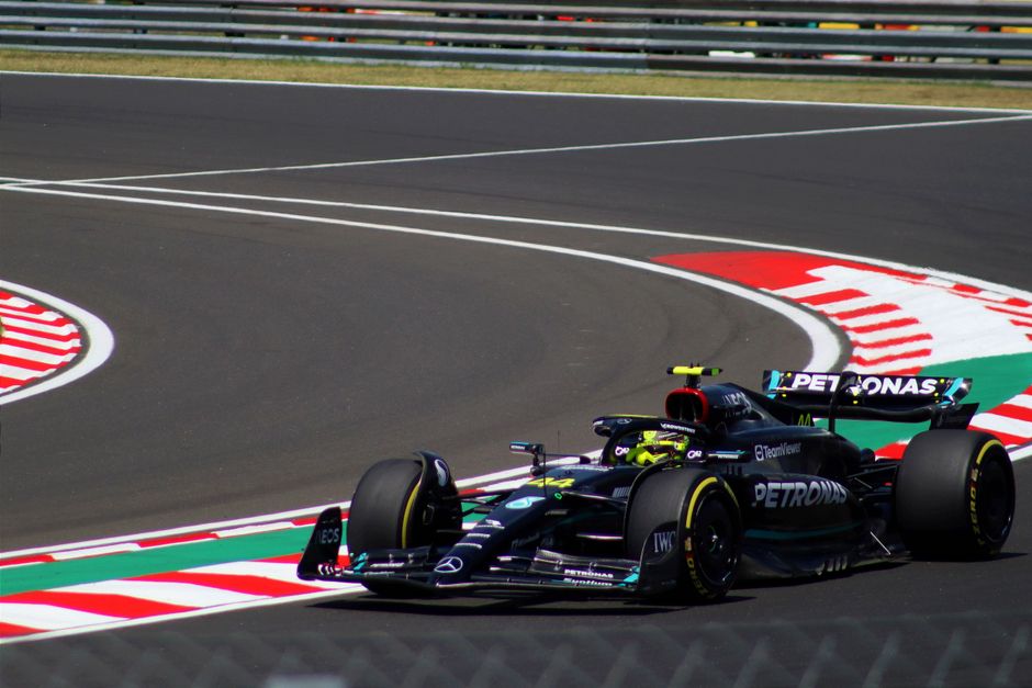 Dynamic shot of a Formula 1 car speeding around a track curve, showcasing motorsport excitement.