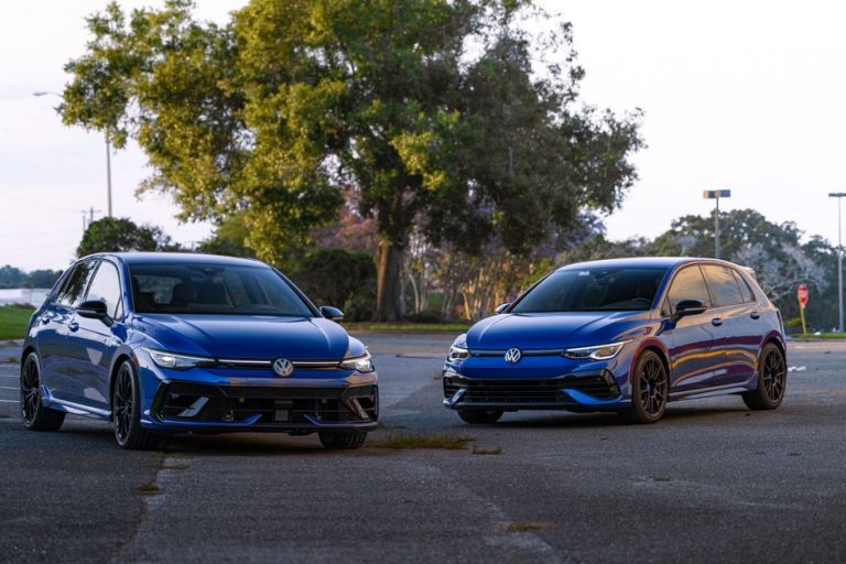 Two blue Volkswagen hatchbacks parked outdoors on a sunny day.