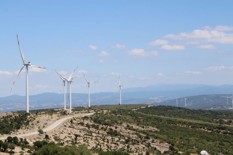 Scenic view of wind turbines on rolling hills in Behram, Çanakkale, Türkiye under a clear blue sky.