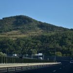 A scenic highway view in Romania, showcasing lush green hills on a sunny day.
