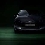 Front view of Hyundai Ioniq 6 electric car in a dimly lit studio setting, highlighting its sleek design.