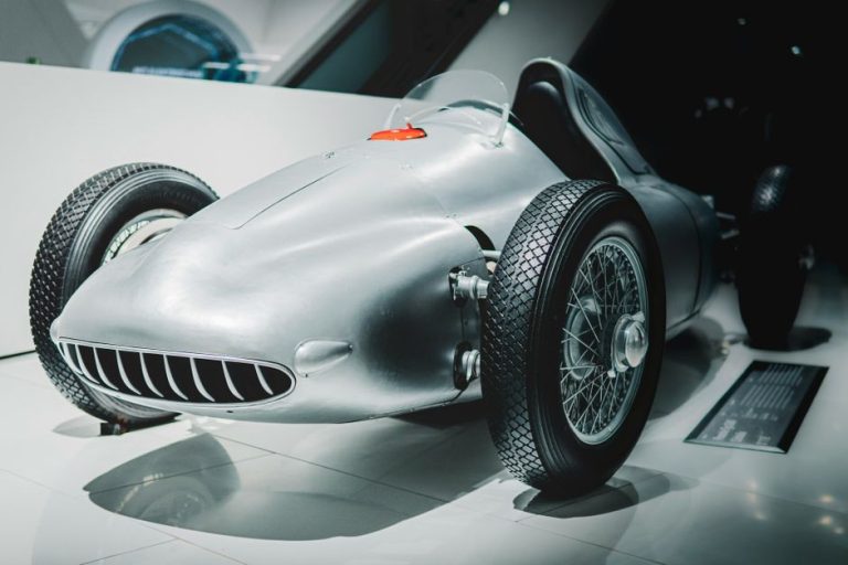 Vintage race car on display in a modern museum setting. Ideal for historical automotive concepts.
