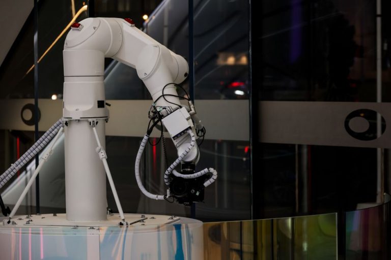 A white robotic arm operating indoors with a modern design and advanced technology.