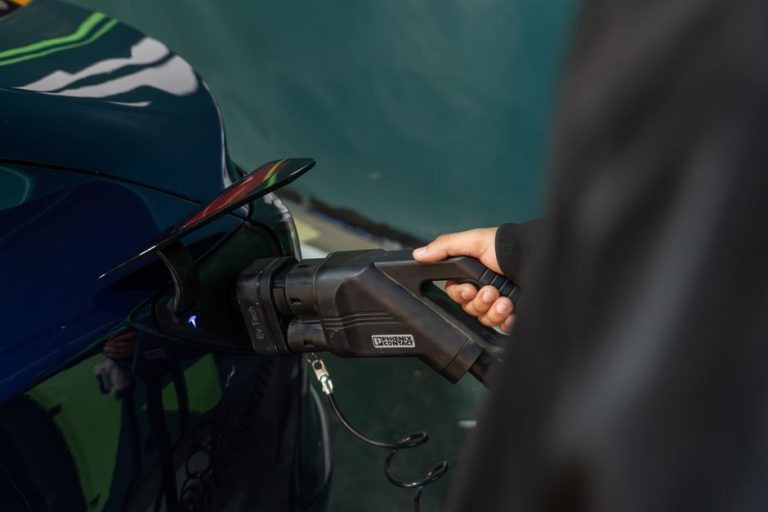 Close-up of an electric vehicle being charged at a station.