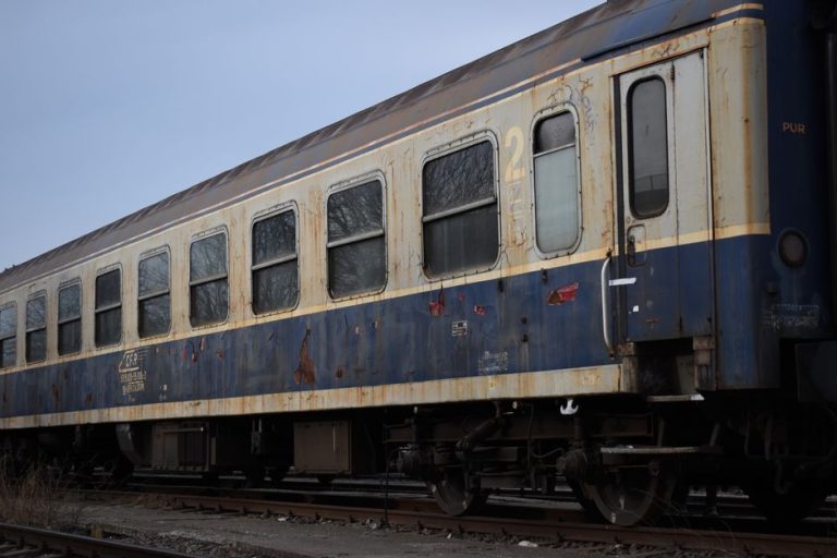 A rusty, abandoned train car on railway tracks in Sibiu, Romania.