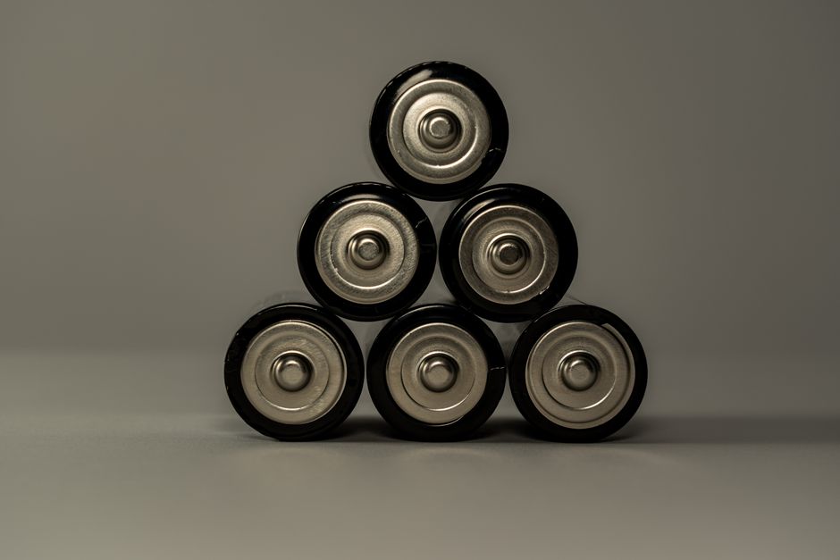 Metallic AA batteries stacked in a pyramid shape, symbolizing power and energy storage.