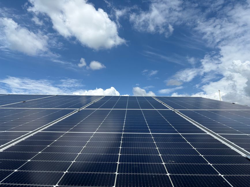 Solar panels generating renewable energy beneath a clear blue sky in Dehradun, India.