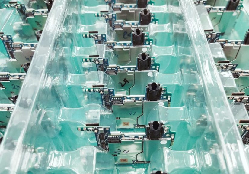 Detailed view of organized electronic circuit boards in a production setting.
