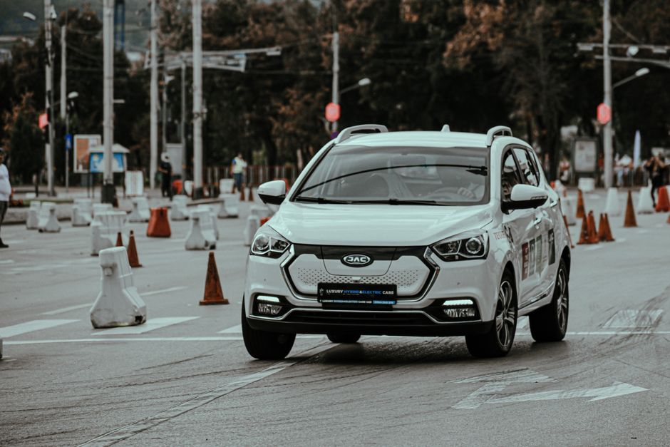 White car racing during urban rally and driving down paved street in daylight
